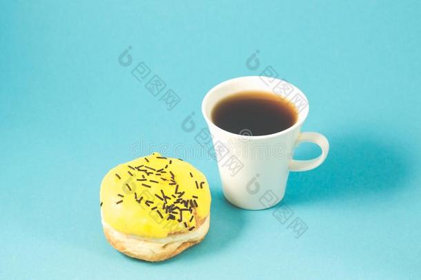 油炸圈饼和咖啡杯子隔离的向蓝色背景/油炸圈饼和咖啡