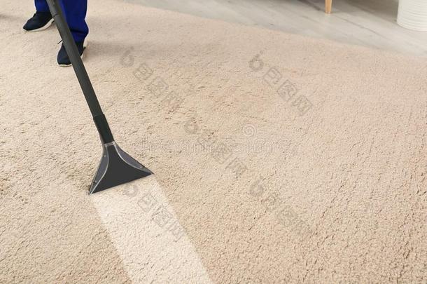 男人消除泥土从地毯和专业的真空清洁剂