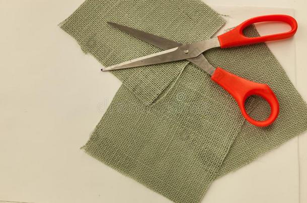 正方形灰色粗麻布织物锋利的大剪刀断开的向顶关于织物
