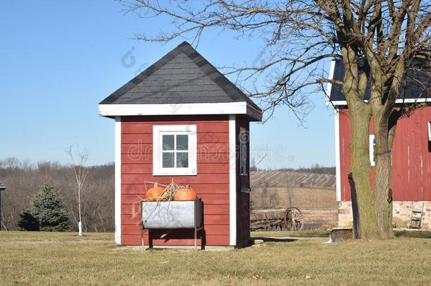 一小的红色的和白色的农场棚和一bl一ck屋顶和窗向