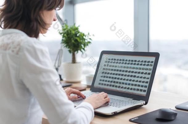 办公室工人打字,工作的在她工作场所,使用便携式电脑.