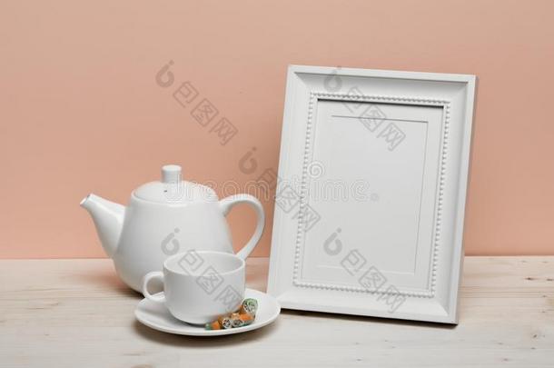 白色的框架和杯子和茶壶向白色的书桌在近处粉红色的墙
