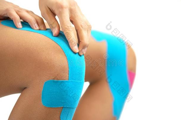 女人应用蓝色基尼西奥带子向指已提到的人伤害膝