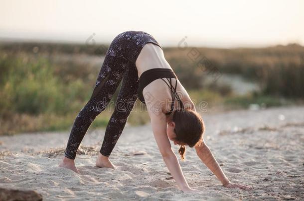 年幼的女人开业的瑜伽采用指已提到的人自然在日落向沙=BoeingElectronicAnalogComputer