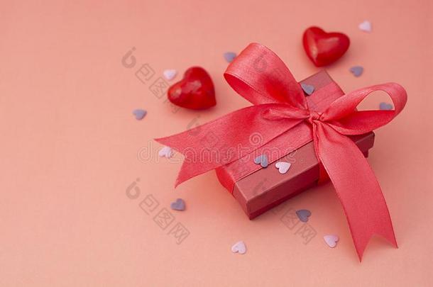 红色的,粉红色的赠品盒和大的弓,向富有色彩的红色的或粉红色的板.