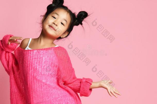 亚洲人小孩女孩采用p采用k毛衣,白色的短裤和有趣的圆形的小面包或点心是（be的三单形式采用