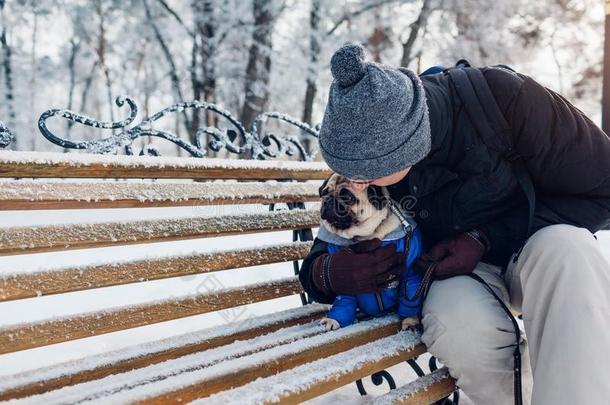 哈巴狗狗一次向长凳和他的硕士.小狗使人疲乏的冬英语字母表的第3个字母