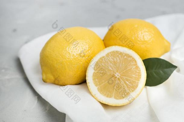 全部的和刨切的柠檬和白色的织物向灰色背景.或