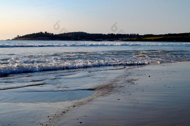 温和的波向卡梅尔海滩在日落