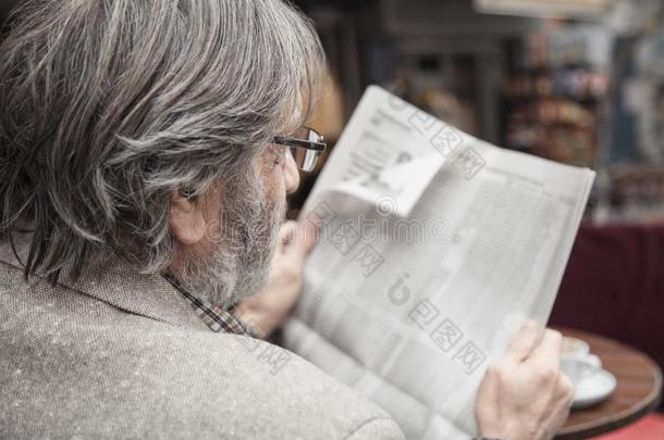 较高的男人阅读报纸采用在户外