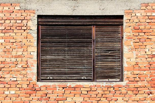 有裂缝的木制的窗窗帘向老的残破的窗框架亩