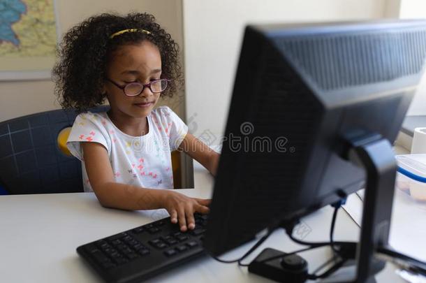 前面看法小的女学生使用桌面personalcomputer个人计算机在书桌采用<strong>班级</strong>