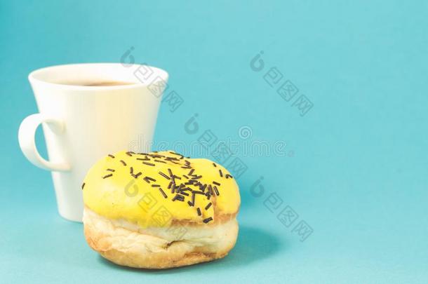油炸圈饼和咖啡杯子向蓝色背景/油炸圈饼采用黄色的装玻璃decrease减少