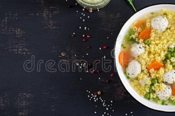 意大利人肉丸汤和世界上的小星星面团采用碗向黑的表.
