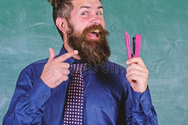 教师有胡须的男人和订书机黑板背景.准备