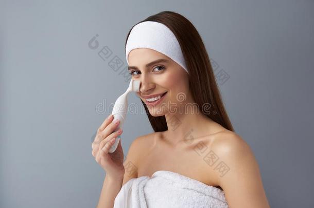 迷人的年幼的女人使用毛孔清洁刷子后的沐浴