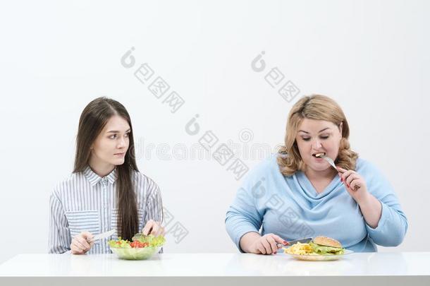 苗条的女孩食物健康的食物,肥的女人食物对有害的快的食物