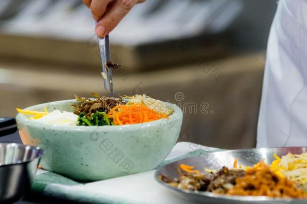 韩式拌饭,传统的朝鲜人烹饪韩式拌饭,厨师准备的kick-off开球