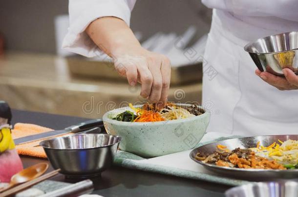 韩式拌饭,传统的朝鲜人烹饪韩式拌饭,厨师准备的kick-off开球