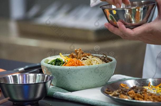 韩式拌饭,传统的朝鲜人烹饪韩式拌饭,厨师准备的kick-off开球