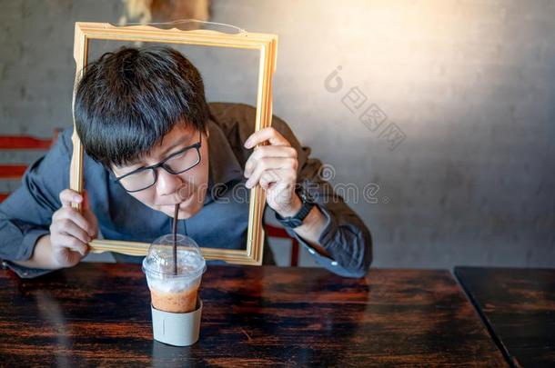 亚洲人男人喝饮料奶茶水通过照片框架