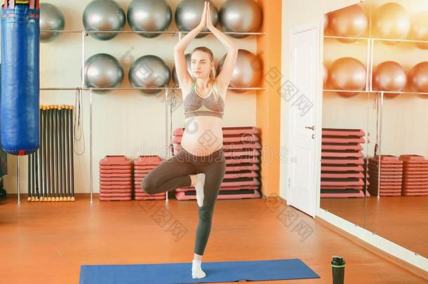 瑜伽为怀孕的女人.年幼的美丽的怀孕的女孩起立