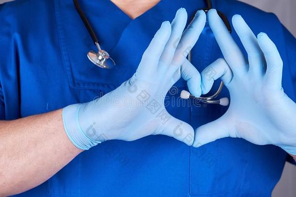 医生采用蓝色制服和老的胶乳拳击手套show采用g心手势