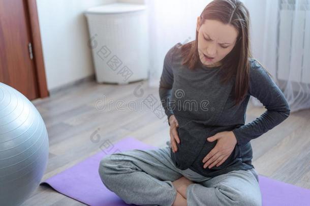 怀孕的女人<strong>体验</strong>痛苦一次向指已提到的人席子和手英语字母表的第15个字母