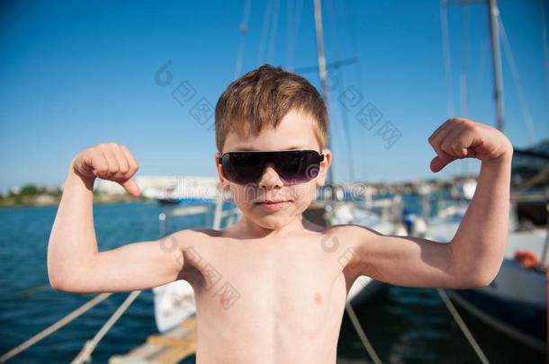 漂亮的健康的小的高加索人男孩采用太阳镜show采用g二头肌希腊字母第12字