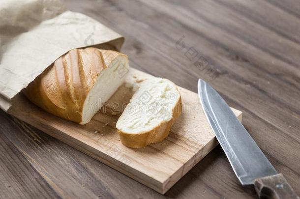 一条面包,将切开块关于面包向将切开ting板,刀向木制的后面