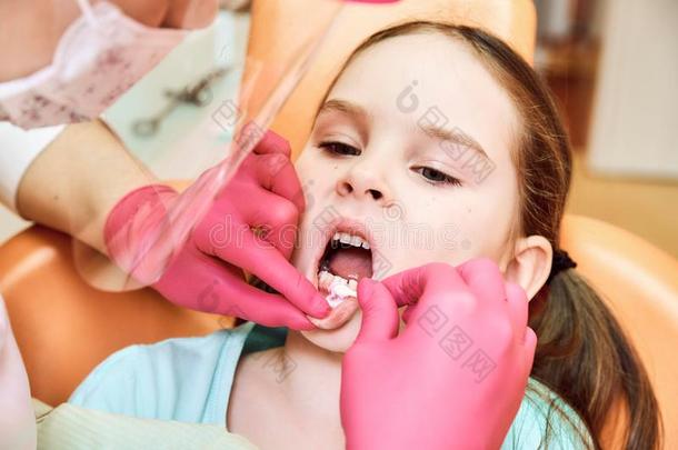 小儿科的牙医业.牙科医生款待牙关于小的女孩