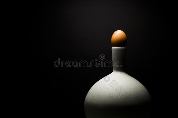 灰色的有机的装饰瓶和棕色的鸡蛋,反对黑的背景.土壤-植物-大气连续体