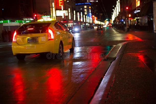 黄色的出租车汽车操纵雨夜城市湿的沥青红色的反射