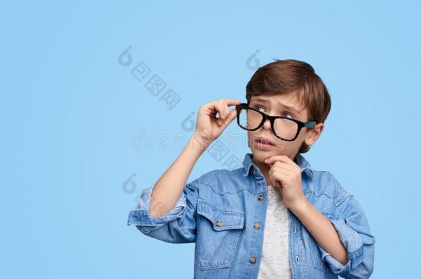 沉思的聪明的男孩采用眼镜look采用g离开