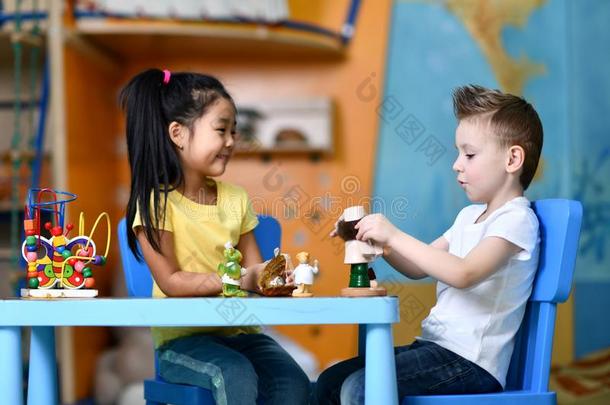 两个小孩男孩和女孩坐在指已提到的人表和比赛玩具医生