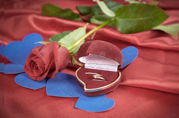 钻石戒指和玫瑰向明亮的红色的背景