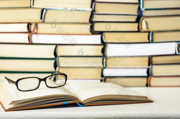 书背景,敞开的书和眼镜向白色的木制的表采用