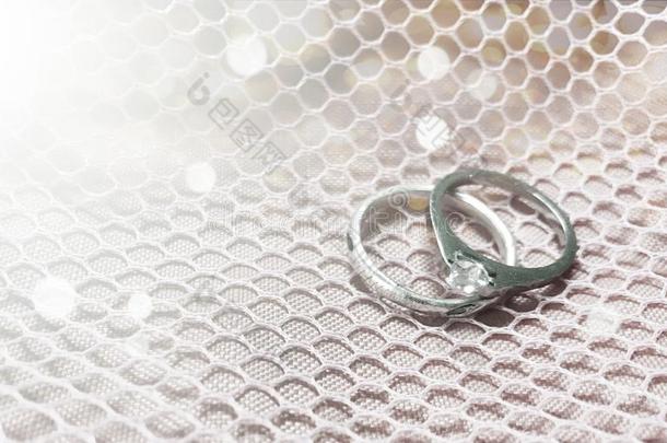 婚礼<strong>钻石戒指</strong>向白色的织物焦外成像背景