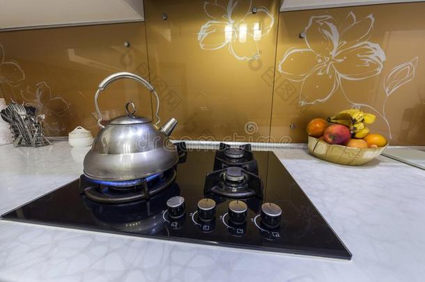 发光的不锈的茶水壶茶水pot和炎热的水向燃烧的