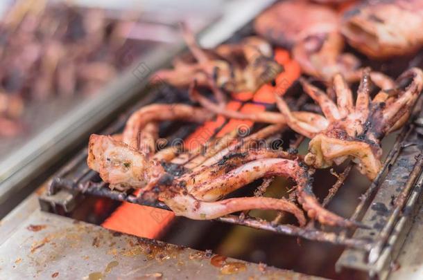 新鲜的乌贼<strong>触手</strong>向燃烧的在亚洲人地方的交易barbecue吃烤烧肉的野餐台