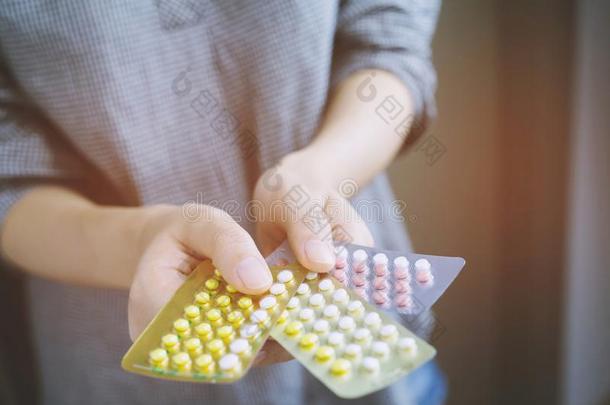 年幼的女人手<strong>避孕用具</strong>药丸向和富有色彩的药丸s剥光