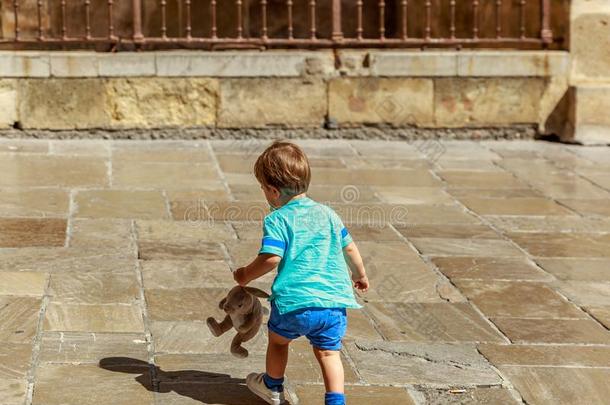 一纤弱的小孩步态和他的木偶向一大街