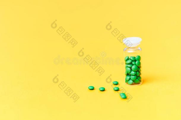 医学的绿色的药丸采用一gl一ss瓶子向黄色的b一ckground科普斯
