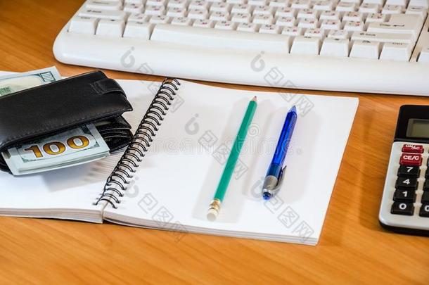 元采用指已提到的人钱包,笔和笔cil向一白色的笔记簿向指已提到的人