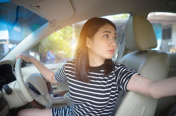 年幼的亚洲人女人操纵汽车保持轮子旋转大约有样子的