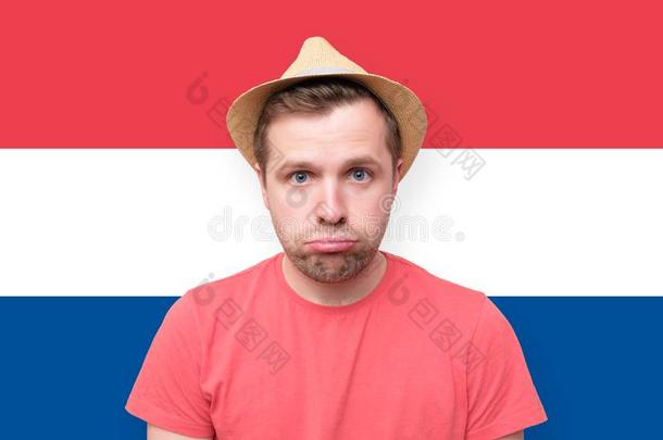 悲哀的旅行者男人向荷兰人的旗背景