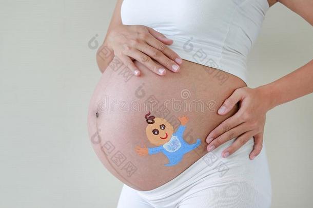 关在上面<strong>大</strong>的<strong>胃</strong>关于怀孕的女人描画的幸福的婴儿