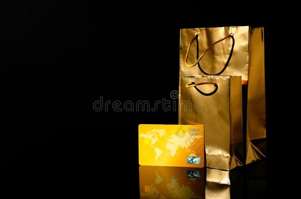 金色的购物袋和信誉卡片向黑的背景