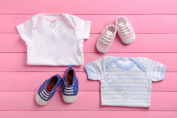 <strong>婴儿衣服</strong>和鞋子向粉红色的木制的背景
