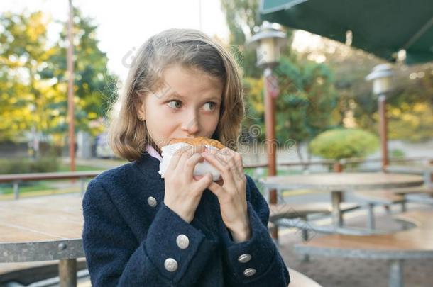 女孩首要的学校学生食物汉堡包,三明治在一户外的